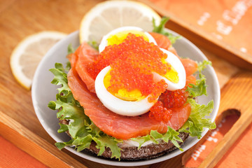 Sandwich with salted salmon, egg and red caviar