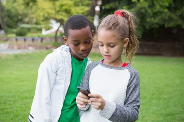 Cute little children looking at smartphone