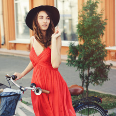 Beautiful woman in dress with bike