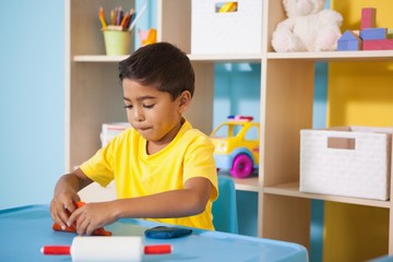 Cute little boys playing with modelling clay in classroom