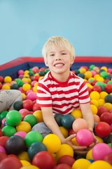 Fototapeta na wymiar Happy boy playing in ball pool