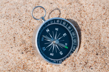 Fototapeta na wymiar Compass on the sea sand.