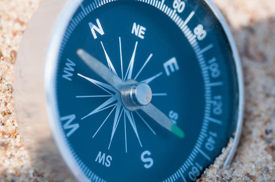 Compass on the sea sand. Close up.