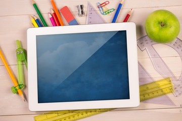 Composite image of digital tablet on students desk