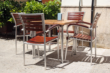 Fototapeta na wymiar Street restaurant- wooden table and chairs