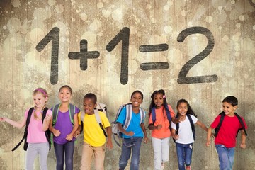 Obraz premium Composite image of elementary pupils running