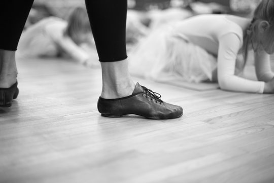 Feet of trainer in ballet school for small girs