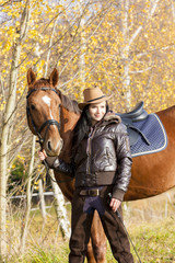 equestrian with her horse in autumnal nature