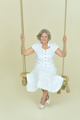 Beautiful elderly woman on swing