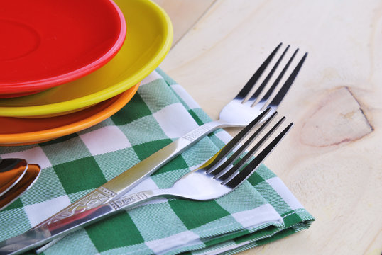 Close-up of stainless fork and spoon on tablecloth with red,yell