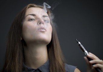 Elegant woman smoking e-cigarette with smoke