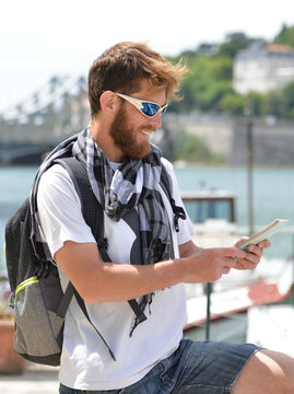 Lost bearded male tourist holding a map and gesturing with hands