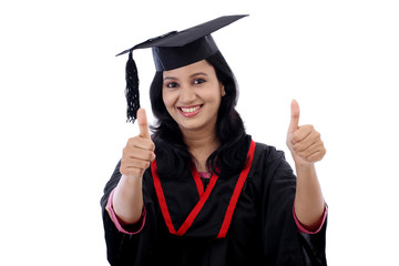 Smiling young graduation student making thumbsup gesture