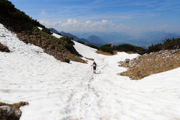 Fototapeta na wymiar Bergsteiger allein auf Schneefeld beim Abstieg