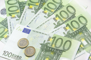 Close-up of 100 Euro banknotes with euro coins isolated on white