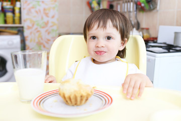 amusing baby eating cupcake and milk