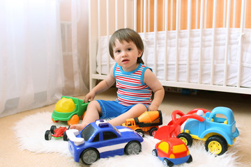 lovely baby boy playing cars