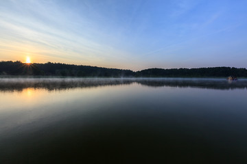Sonnenaufgang am Ufer vom See
