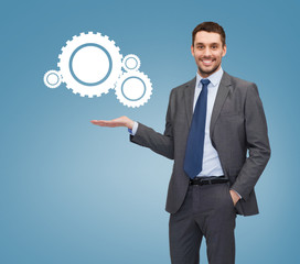 smiling businessman holding settings icon