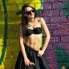 Sexy girl in  skirt posing with a skateboard 