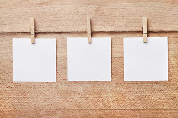 Drei Notizzettel vor braunem Holzhintergrund