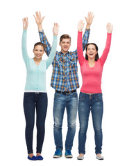 Obraz premium group of smiling teenagers with raised hands