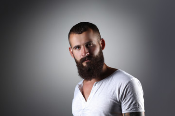 Obraz premium Portrait of handsome bearded man standing, isolated on grey