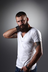 Fototapeta premium Portrait of handsome bearded man standing, isolated on grey