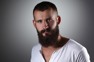 Fototapeta premium Portrait of handsome bearded man standing, isolated on grey