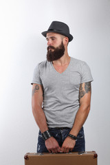 Portrait of handsome bearded man in hat standing with bad,