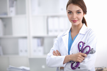 Portrait of happy successful young female doctor holding a