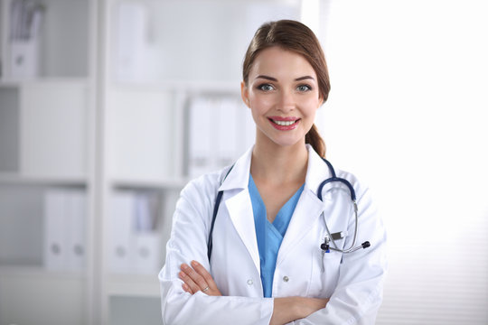 Portrait Of Young Woman Doctor With White Coat Standing  In