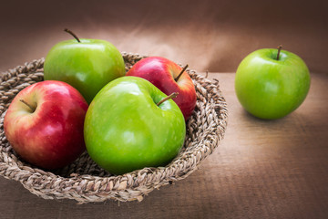 Green apple and red apple in basket, still life