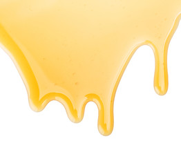 Honey dripping from white surface