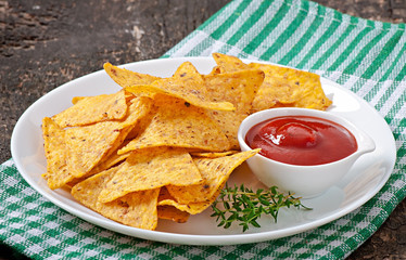 Nachos and tomato dip decorated with thyme leaves