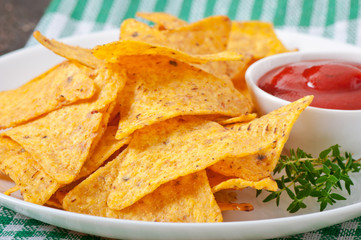 Nachos and tomato dip decorated with thyme leaves
