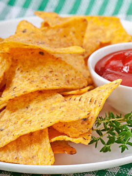 Nachos and tomato dip decorated with thyme leaves