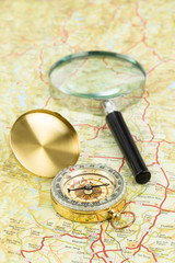Retro compass and magnifier on a road map