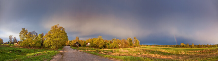 Rainbow after the storm over the spring field