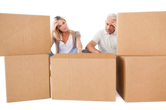 Stressed couple looking at moving boxes