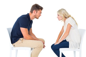 Obraz premium Young couple sitting in chairs arguing