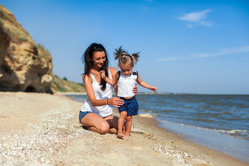 Fototapeta na wymiar girl with mother on the beach by the sea