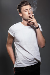 Handsome young man smoking cigarette