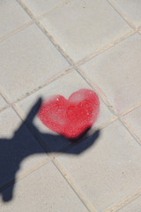 shadow of hand with red heart