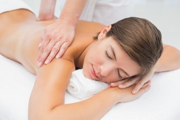 Fototapeta na wymiar Attractive young woman receiving back massage at spa center