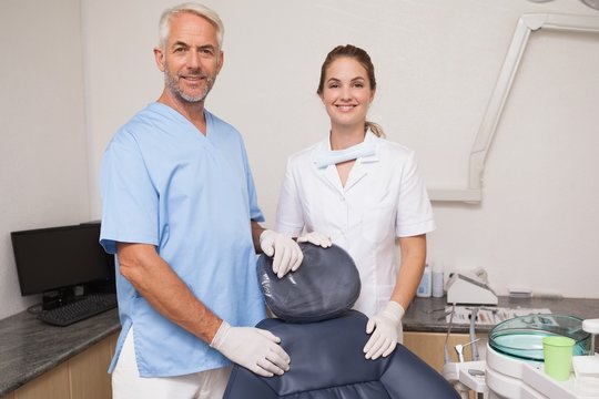 Dentist and assistant smiling at camera