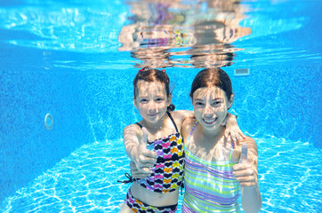 Happy active kids swim in pool and play underwater