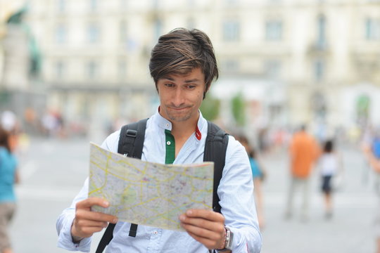 Young tourist watching the map in the city center