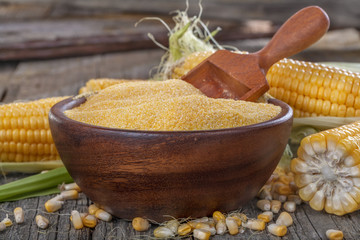 corn grits polenta in a wooden bowl on old wooden table © DDsign