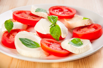 Caprese salad with mozarella cheese, tomatoes and basil